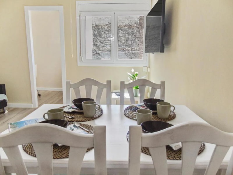 Mesa de comedor con vajilla y ambiente cálido y funcional