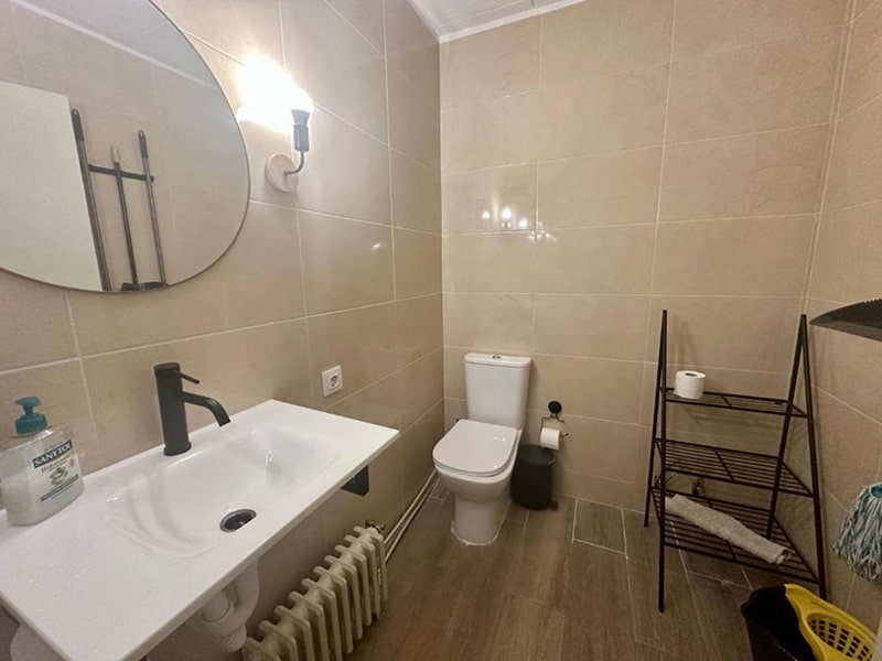 Baño amplio con lavabo moderno y acabados en tonos beige suaves