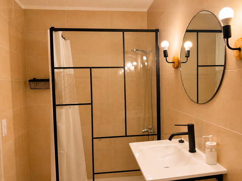 Apartamento de Cozycatalonia | Vista del baño Cuarto de baño moderno con ducha diáfana y acabados en tonos cálidos