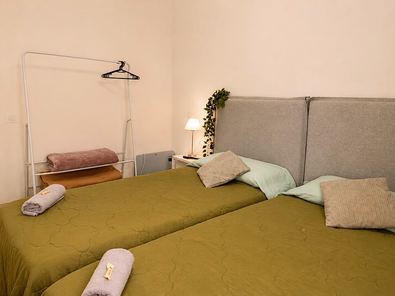 Dormitorio con dos camas individuales y decoración cálida.