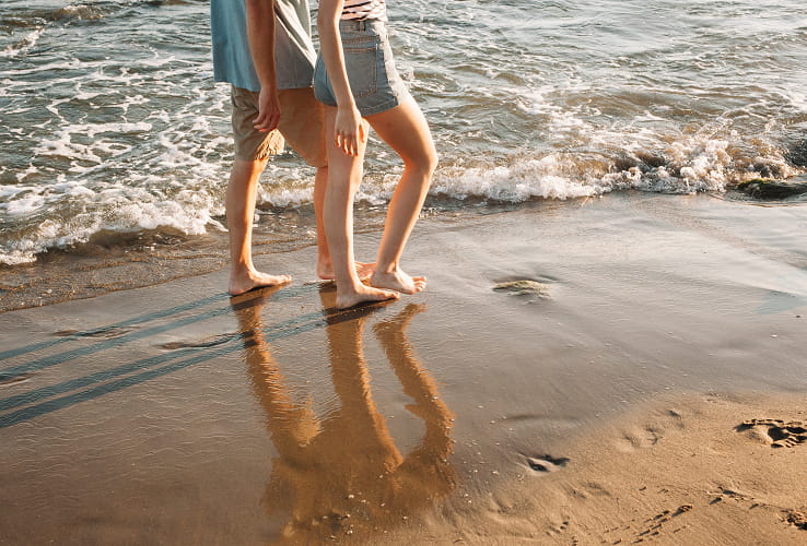 Pareja caminando por la orilla de la playa