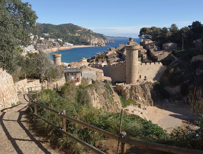 Camino con vistas a un castillo histórico y al mar Mediterráneo