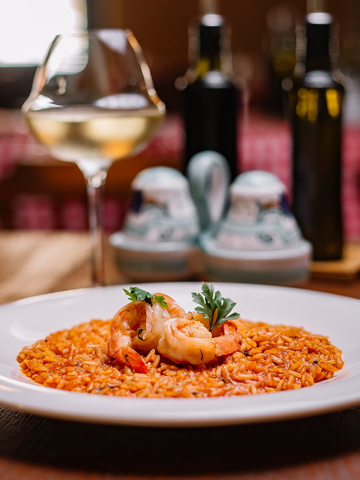 Plato de arroz con gambas acompañado de vino