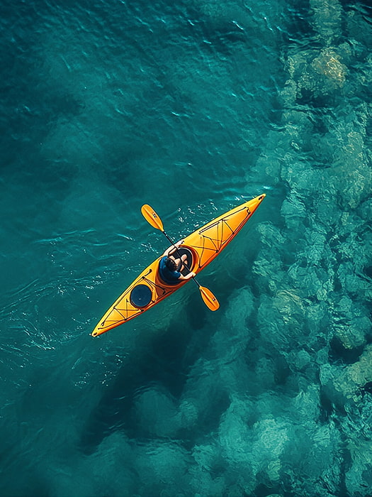 Persona practicando kayak sobre aguas cristalinas
