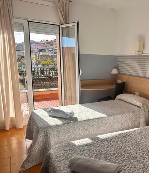 Habitación luminosa en Blanes Habitación con dos camas individuales y salida a una terraza exterior