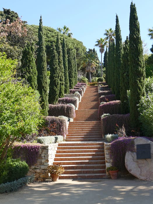 Jardines cerca de Can Setmanes Escalinata rodeada de vegetación mediterránea y cipreses