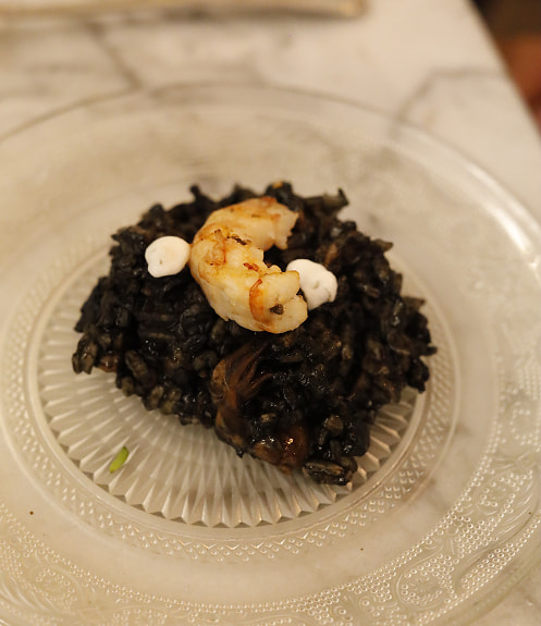 Plato con arróz negro y una gamba pelada