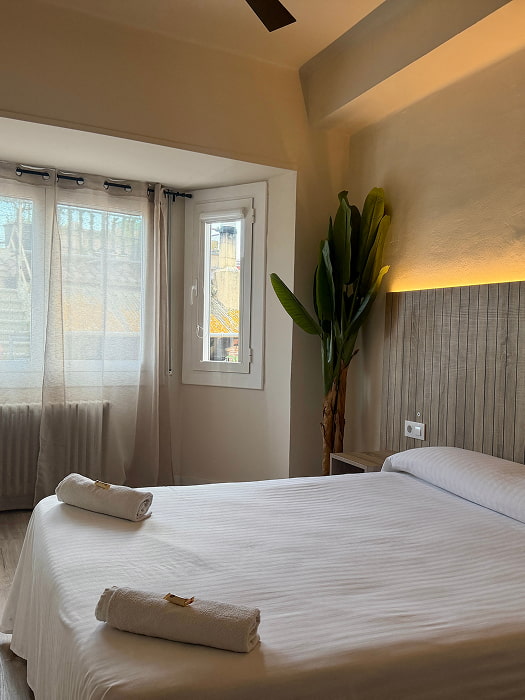 Habitación  con cama cómoda y  ventanales