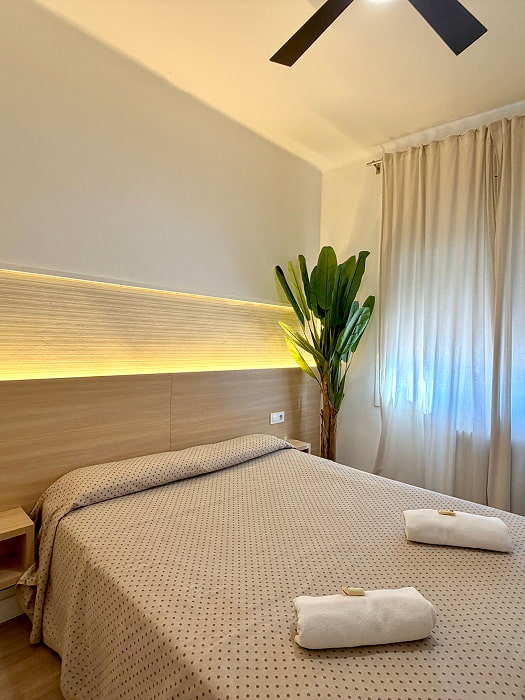 Dormitorio doble con cama grande e iluminación cálida