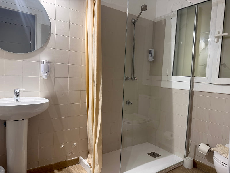 Baño moderno con ducha amplia y acabados en tonos neutros