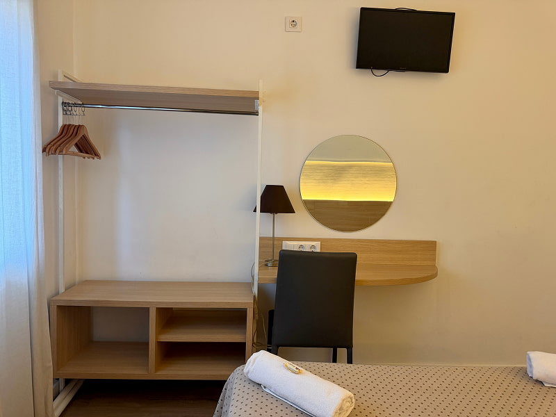 Dormitorio con escritorio, espejo redondo y detalles en madera