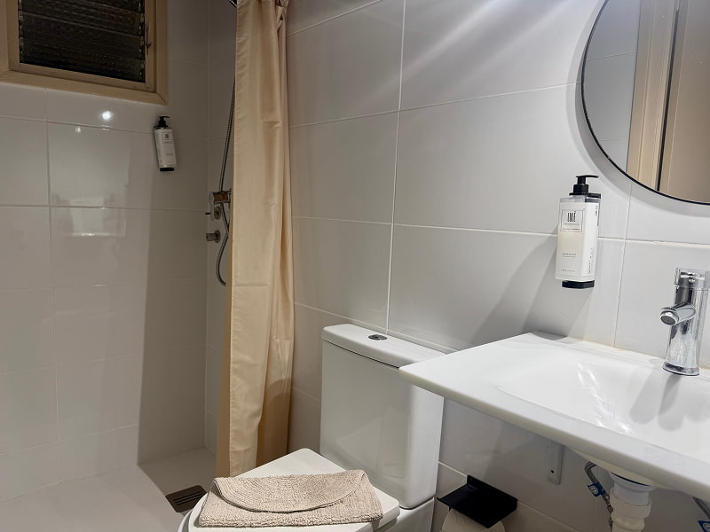 Baño moderno con ducha y acabados en tonos claros