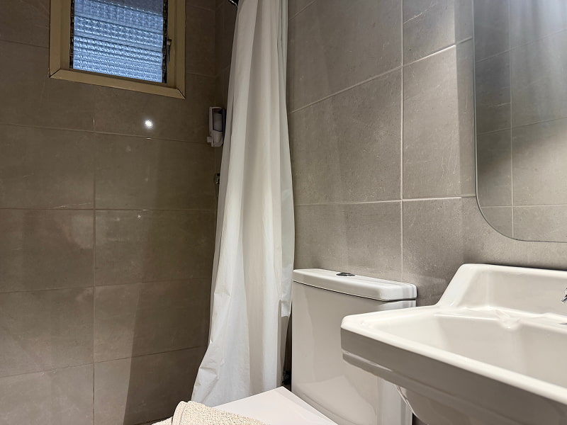 Ducha amplia con acabados modernos en tonos neutros