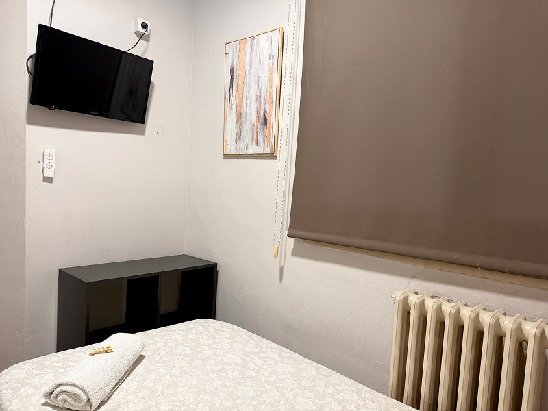 Habitación individual con televisión y mobiliario funcional