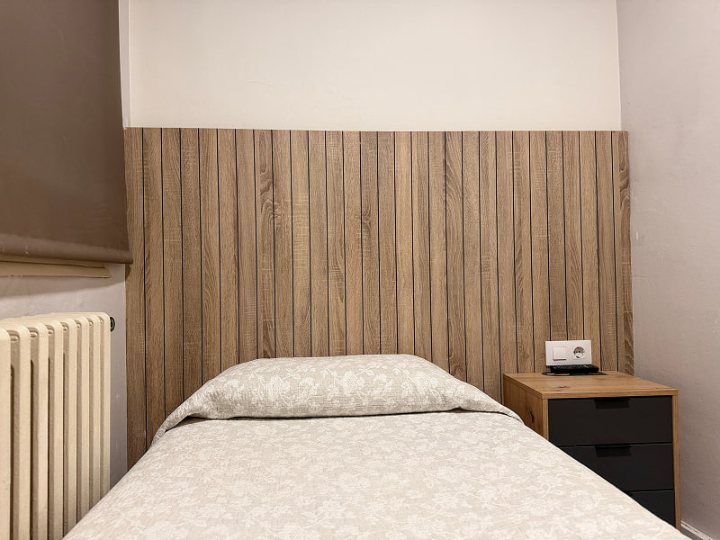 Dormitorio con cama individual y detalles cálidos