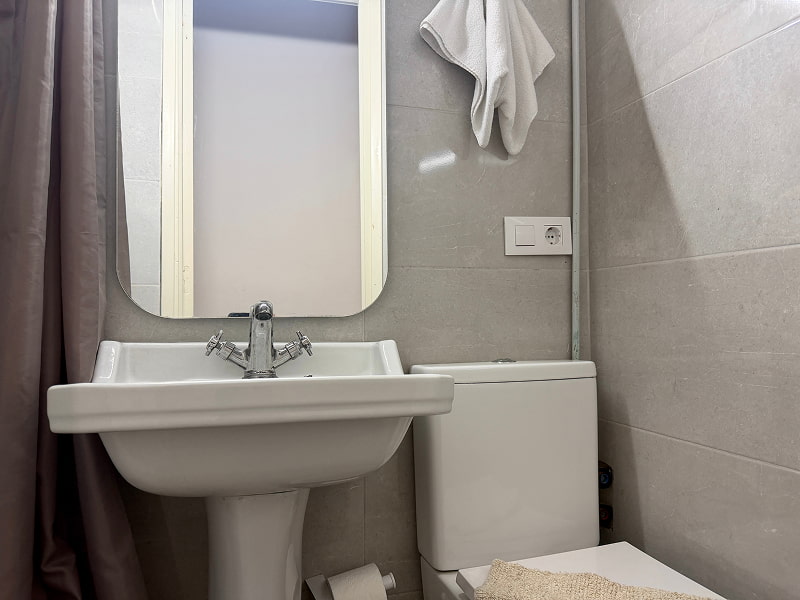 Baño con ducha y acabados neutros