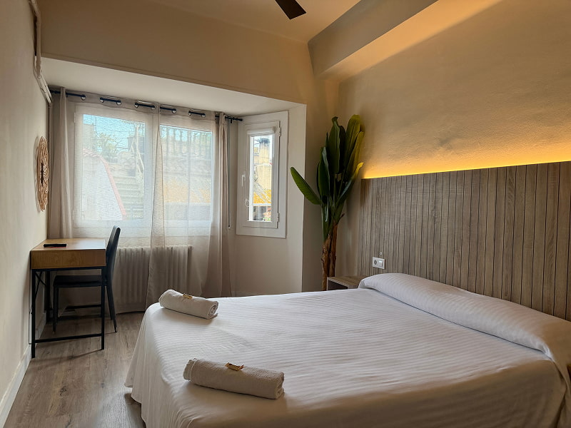 Vista general de una habitación amplia con cama doble y luz natural