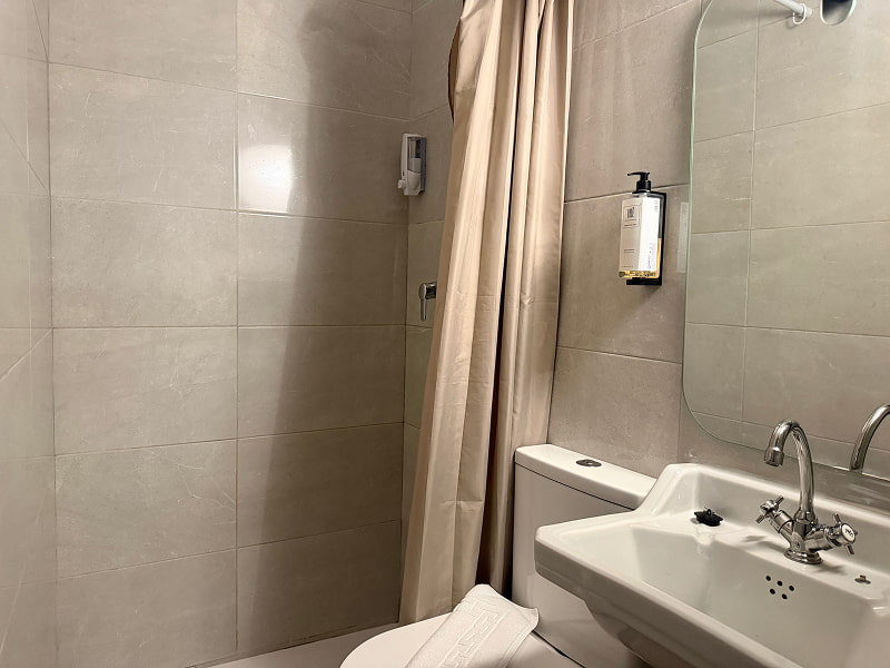 Cuarto de baño moderno con ducha y acabados minimalistas