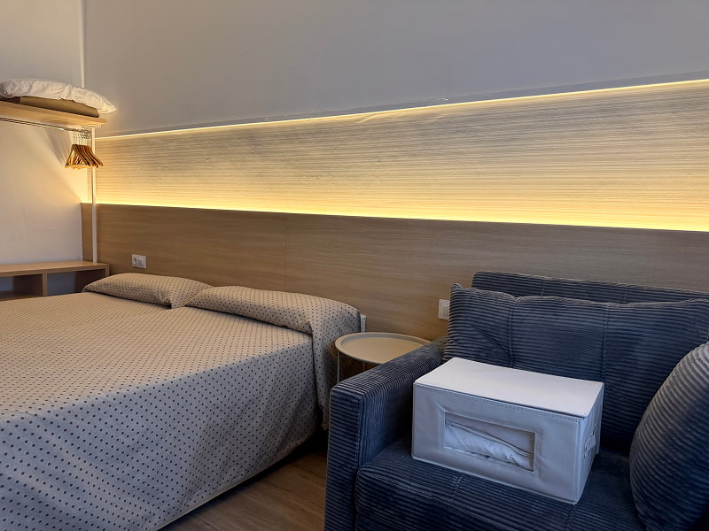 Sofá acolchado junto a la zona de cama en una habitación